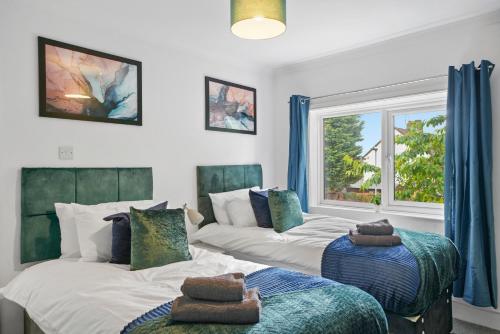 彼得伯勒3 bedrooms with parking ideal for long stays的一间卧室设有两张床和窗户。