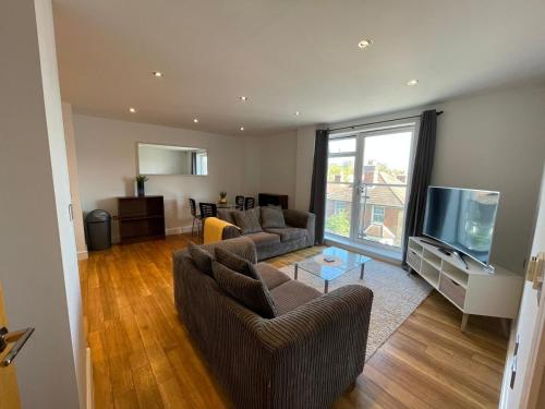 吉尔福德Blue Sky Apartments@ Abbots Yard, Guildford的客厅配有2张沙发和1台平面电视
