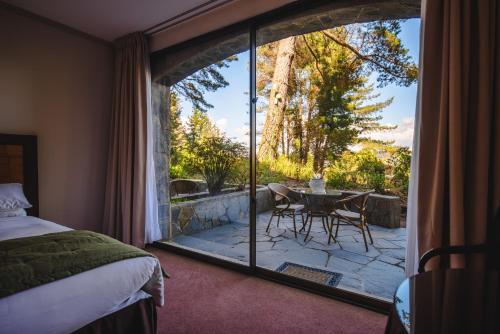 瓦尔迪维亚普塔德尔苏尔酒店的一间卧室享有带桌椅的庭院的景致。