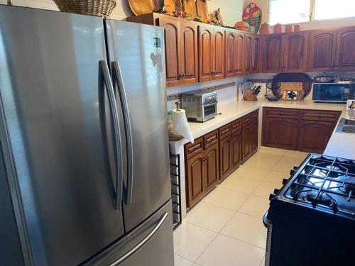 普拉亚科罗纳多Coronado Beachfront tropical home!的厨房配有不锈钢冰箱和炉灶。