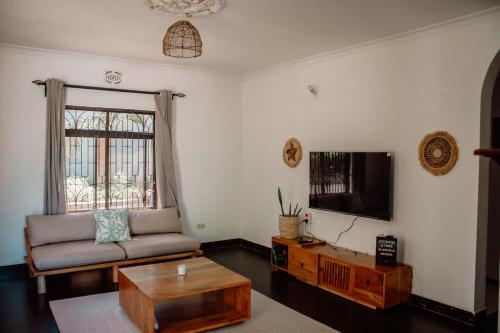 阿鲁沙Tropicana House的带沙发和电视的客厅