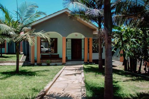 阿鲁沙Tropicana House的前面有棕榈树的房子