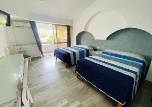 阿瓜斯卡连特斯Hotel La Cascada的酒店客房设有两张床和窗户。