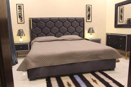 拉合尔Vacation Villa的一间卧室配有一张带2个床头柜的大床
