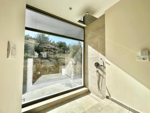路特奇Topos luxury stay Heraion的浴室设有大窗户和淋浴。