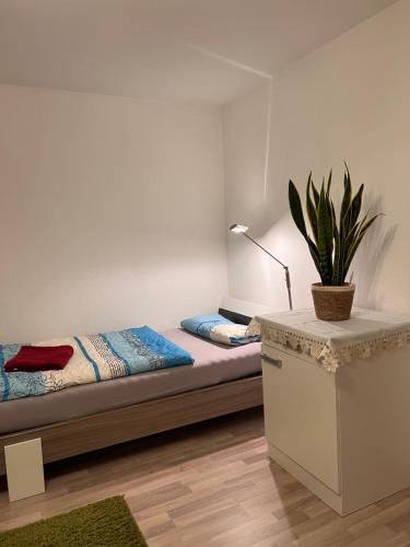 RosenfeldGäste-, Handwerkerzimmer的一间卧室配有一张床和盆栽植物