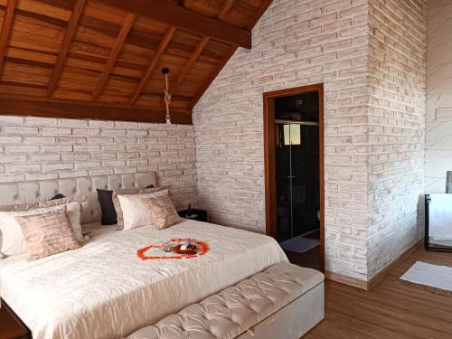 卡曼杜卡亚Pousada rota nas montanhas的卧室设有一张砖墙内的大床