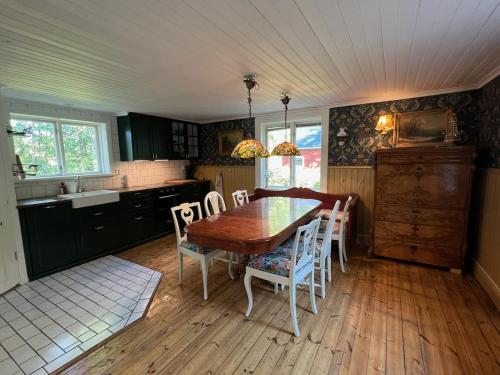 东哈尔马Drömtorp med egen brygga的厨房配有木制餐桌和椅子