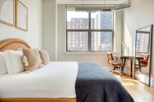 纽约Innovation Inn 3BR in NYC!的一间卧室配有一张床、一张书桌和一个窗户。