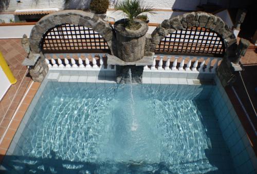 伊斯基亚Hotel Punto Azzurro的一座房子里一个带喷泉的游泳池