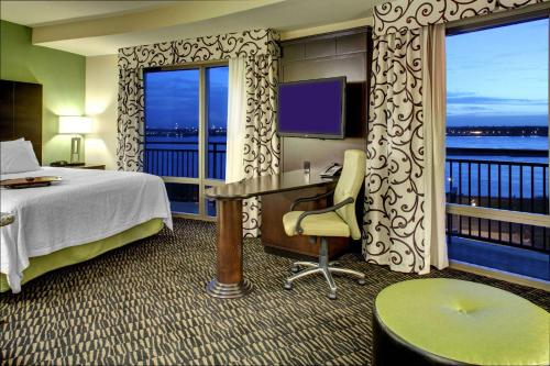 巴吞鲁日巴吞鲁日市中心汉普顿酒店及套房的酒店客房设有一张床、一张书桌和窗户。