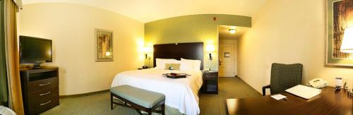 布伦特伍德Hampton by Hilton的配有一张床和一张书桌的酒店客房