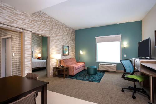 普弗拉热维尔Home2 Suites by Hilton Pflugerville, TX的酒店客房配有一张床和一张带电脑的书桌