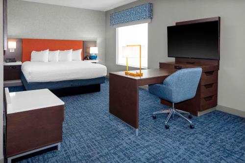 斯德伯克Hampton Inn & Suites Cedar Park North Austin, Tx的酒店客房配有一张床和一张书桌及一台电视