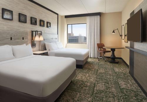 阿普尔顿Hilton Appleton Paper Valley的酒店客房配有两张床和一张书桌