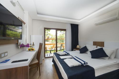 特基罗瓦爱茉莉特基罗瓦酒店 的一间卧室配有一张床、一张书桌和一台电视