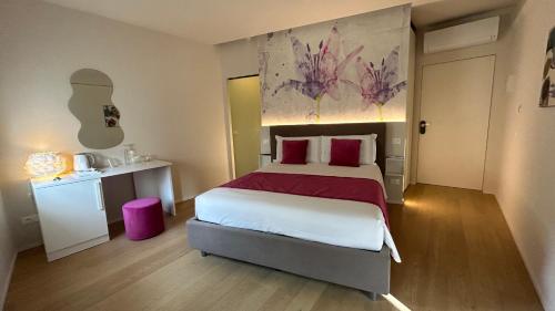 曼托瓦SAN LORENZO Luxury Boutique的一间卧室配有一张带红色枕头的大床