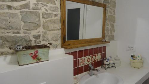 格罗日年Vintage House Daška的浴室水槽设有镜子和石墙