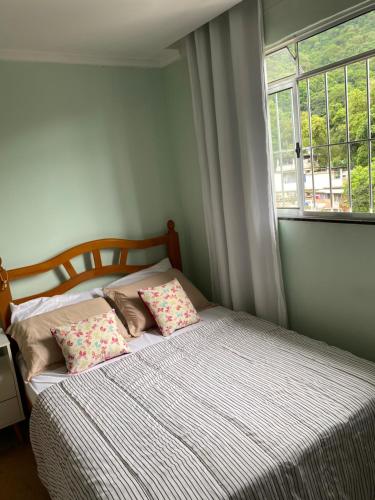 里约热内卢Casa Zona Sul的一间卧室配有带两个枕头的床和窗户