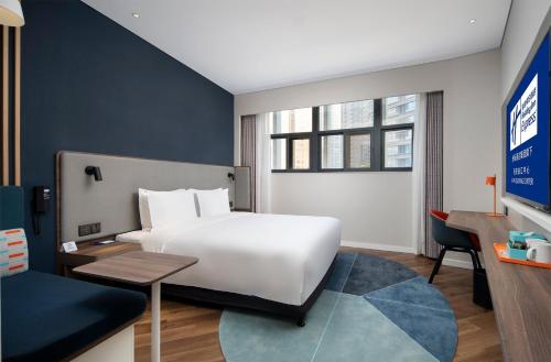 西安西安曲江中心智选假日酒店的配有一张床和一张书桌的酒店客房
