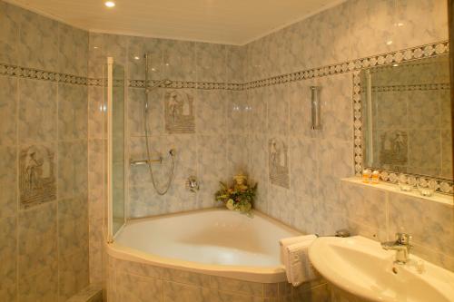 朗根费尔德兰德罗曼酒店的带浴缸和盥洗盆的浴室