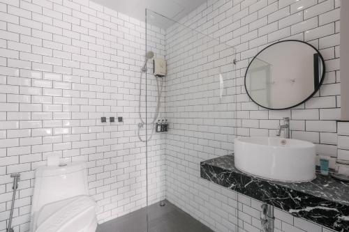 卡塔海滩苏格奥哈那旅馆的白色瓷砖浴室设有水槽和卫生间