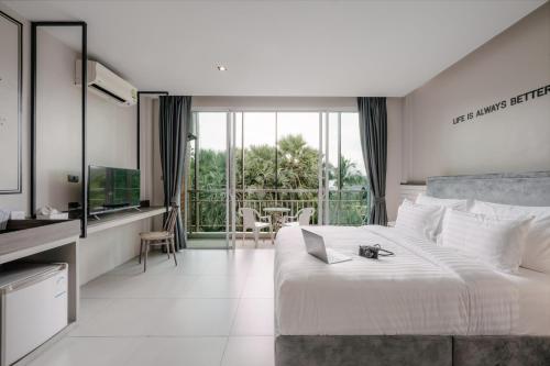 卡塔海滩苏格奥哈那旅馆的卧室配有一张白色大床和电视。