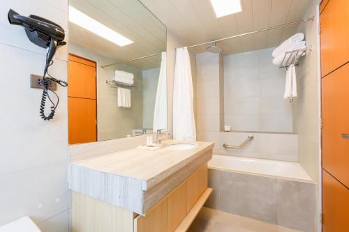 碧瑶Sotogrande Hotel Baguio的浴室配有盥洗盆和浴缸。