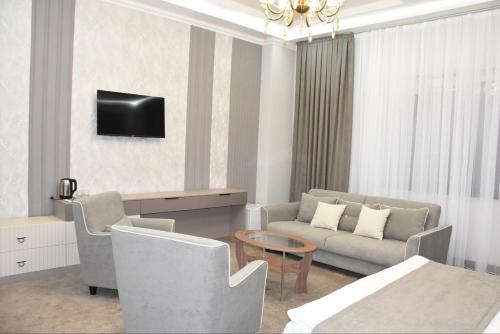 塔拉兹IMPERIAL的客厅配有沙发和墙上的电视