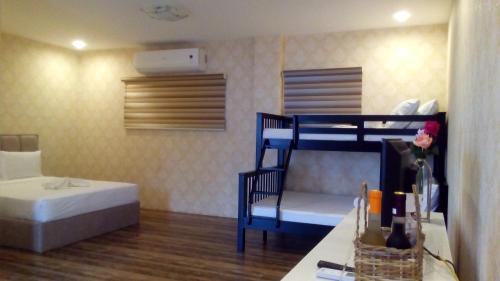 CalapanMahalta Resorts and Convention Center的客房设有两张双层床、一张床和一张桌子。