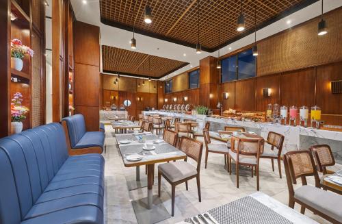 玛琅The Alana Hotel Malang的一间带桌椅的餐厅和一间酒吧