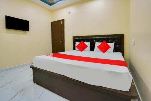ItwāriOYO Flagship Heritage Farm Resort的一间卧室配有一张带红色枕头的大床