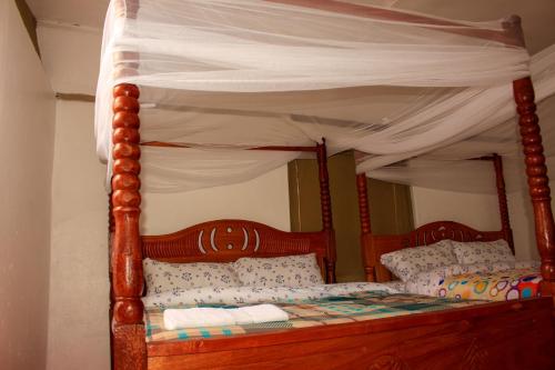 OlolaimutiekEco mara forest camp的卧室内的一张木床和天蓬