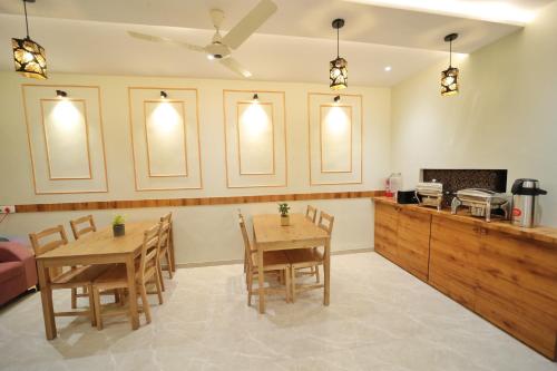 孟买HOTEL ALFA EXECUTIVE的一间带两张桌子的用餐室和一间厨房