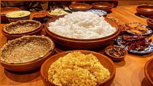 普纳卡Nobgang B&B "Traditional Heritage HomeStay"的餐桌上放着一碗米饭和其他食物