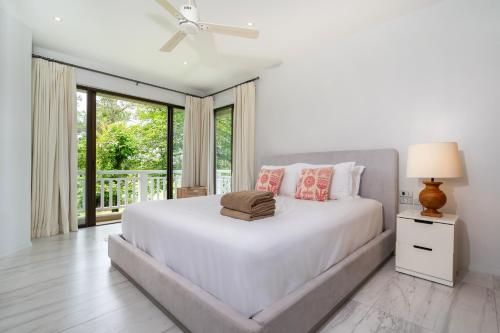 邦涛海滩Spacious 2BR Apartment Allamanda II in Laguna, 10 min from BangTao Beach的白色的卧室设有一张大床和一个窗户