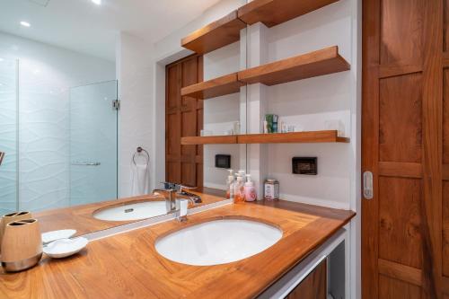 邦涛海滩Spacious 2BR Apartment Allamanda II in Laguna, 10 min from BangTao Beach的一间带水槽和玻璃淋浴的浴室