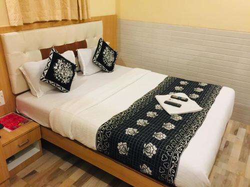 孟买Hotel KF Residency的一张带黑白枕头的床和托盘