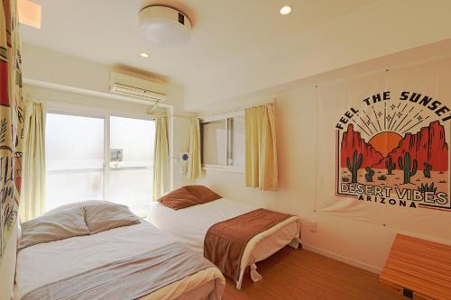 东京V.Close to Shinjuku Kabukicho/Korean Town/FrWIFI D的卧室配有两张床,墙上挂有一张海报