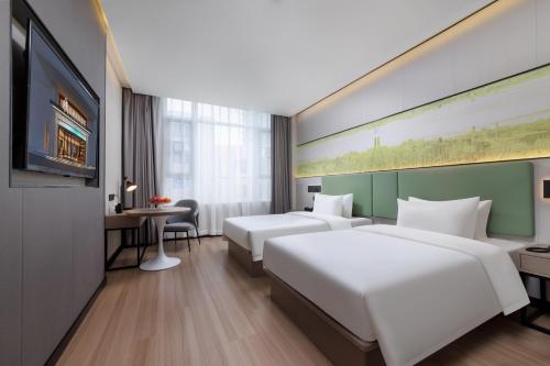 广州翡丽国际酒店的一间酒店客房,设有两张床和电视