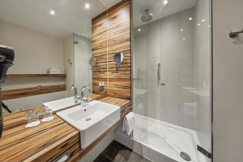 明斯特H4明斯特酒店的浴室配有白色水槽和淋浴。