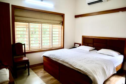 坎努尔Choice Beach House的一间卧室设有一张大床和一个窗户。