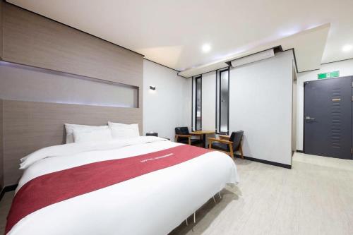 SeosanSeosan Hotel November的卧室配有一张大白色床和红色毯子