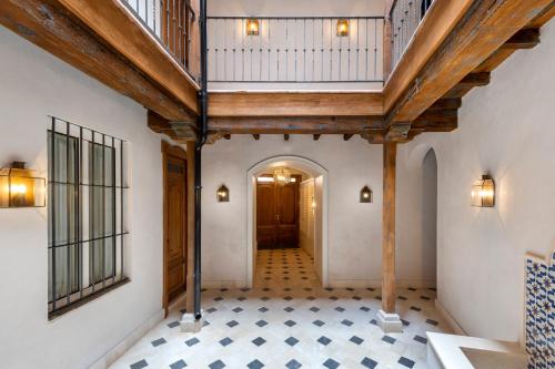 塞维利亚Magno Apartments Casa Pilatos的空的走廊,设有木制天花板和瓷砖地板