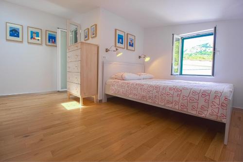 巴斯卡Apartments Baška的一间卧室配有带梳妆台和窗户的床。