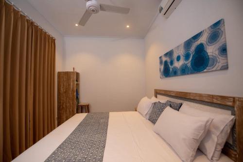沙努尔Asri Bali Sanur Apartment的卧室配有一张床,墙上挂有绘画作品