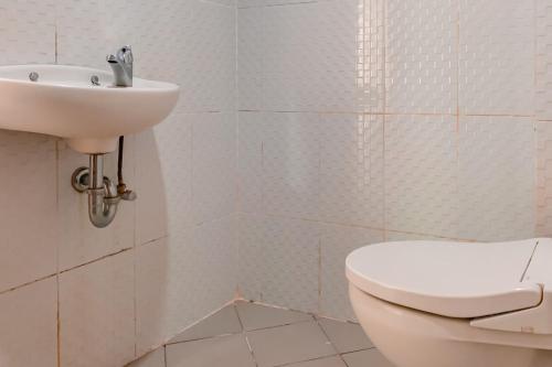 班贾尔马辛Urbanview Hotel AVA Banjarmasin by RedDoorz的白色的浴室设有卫生间和水槽。