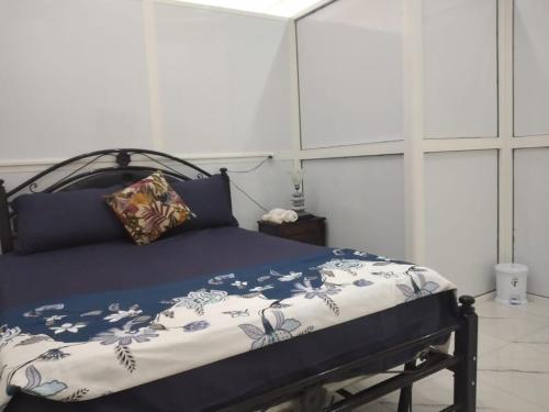 DerouaAirport M V chambre stay的一间卧室配有一张带蓝色和白色棉被的床