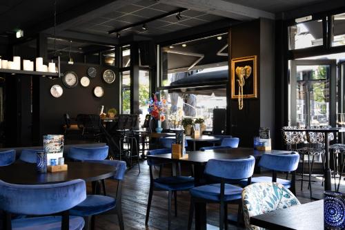 泽芬贝亨Mart9 City Loft的餐厅设有蓝色的椅子和桌子以及窗户。