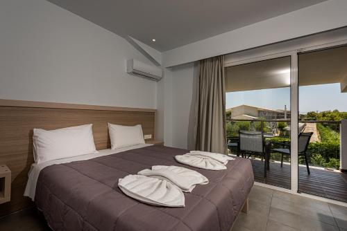 卡拉马孔Caretta Island的一间卧室配有带枕头的床铺和阳台
